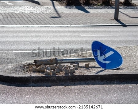 Broken road sign. road sign lies on the road Royalty-Free Stock Photo #2135142671