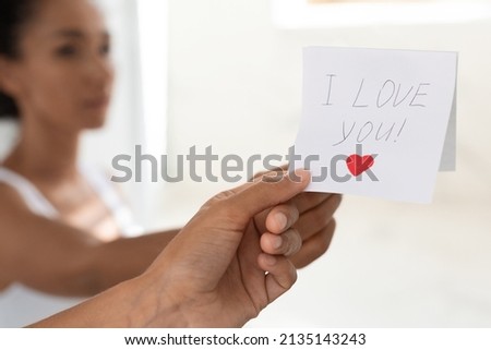 Young Woman Taking Off Sticky Note With I Love You Text On Mirror, Female Reading Card With Handwritten Romantic Messase And Drawn Heart, Cropped Image With Selective Focus, Copy Space
