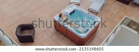 BANNER, LONG FORMAT Drone view. Portrait of young carefree happy smiling woman relaxing at hot tub during enjoying happy traveling moment vacation life against the background of green big mountains