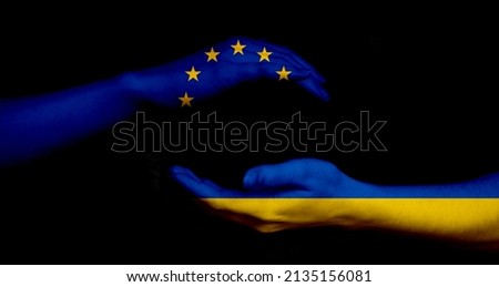 Europe union and Ukraine flags and hands on black background, peace and NATO concept photo