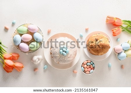 Easter orthodox cakes, chocolate and colourful eggs on white background. View from above. Christian custom. Banner. Festive morning.
