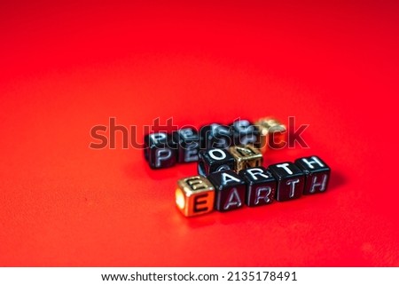 A word on a red background - peace on earth. Letter cubes. During the unrest. During the war.