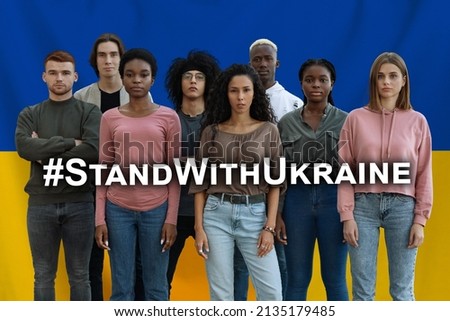 Hashtag Stand With Ukraine Layered Over Multiethnic Group Of People Standing Over Blue Yellow Ukrainian Flag Background, Creative Collage For Patriotism And International Support Concept