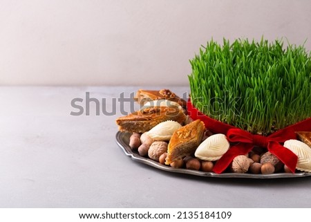 Beautiful Novruz tray with semeni - wheat grass, pakhlava, shekerbura and blooming branch for Spring equinox and new year celebration in Baku, copy space