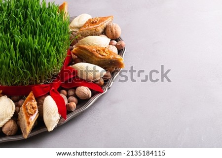 Beautiful Novruz tray with semeni - wheat grass, pakhlava, shekerbura and blooming branch for Spring equinox and new year celebration in Baku, copy space