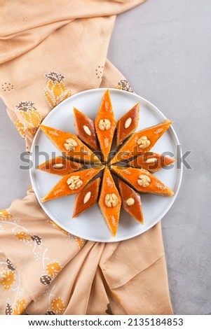 Plate of Azerbaijani national pastries for Novruz - Ganja and Baku style pakhlava on silk scarf kelagai for Novruz, spring equinox and new year celebration in March. Copy space   Royalty-Free Stock Photo #2135184853