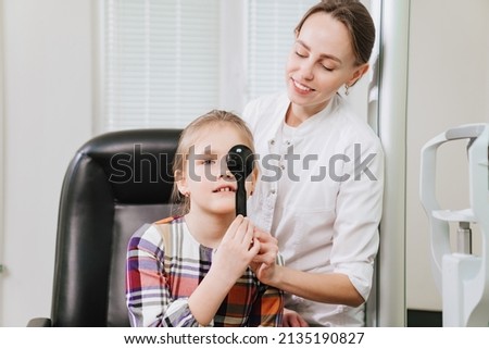 the doctor makes a diagnosis of vision a little girl's. advertising of the clinic, treatment and correction of vision.a sign projector. modern automatic multifunctional medical device. 
