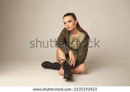 Portrait of caucasian young attractive woman posing on a white floor in white studio. Model tests of pretty girl on cyclorama.