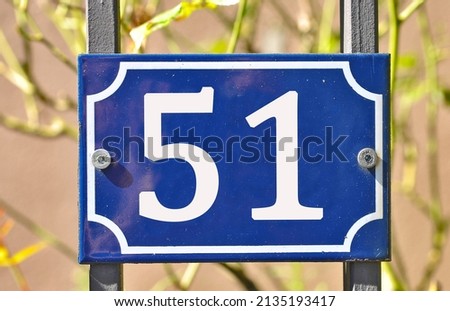 A blue colored number plaque, showing the number fifty one (number 51)