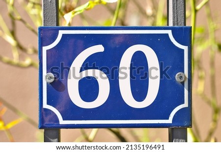 A blue colored number plaque, showing the number sixty (number 60)