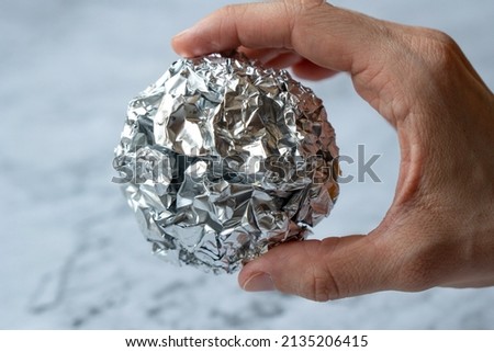 Wrinkled ball of aluminium foil, a material often used in the kitchen. Royalty-Free Stock Photo #2135206415