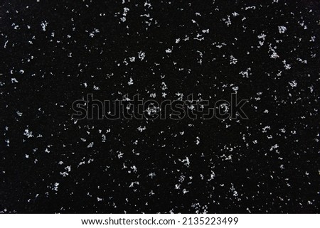 White snow on a black background. It snows at night.