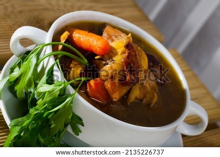 Cock-a-leekie - Scotland national chicken soup served with parsley in white bowl.. Royalty-Free Stock Photo #2135226737