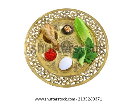 Pesah celebration concept (jewish Passove holiday). Traditional plate text in hebrew: Passover, horseradish, celery, egg, bone, maror, sweet dates jam. Isolate on white