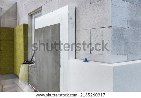construction of a house and insulation of the wall of the house with layers of modern thermal insulation materials Royalty-Free Stock Photo #2135260917
