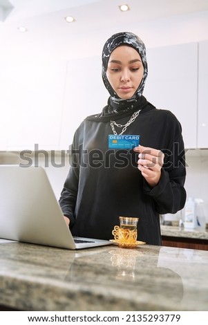 Muslim woman doing online shopping at home