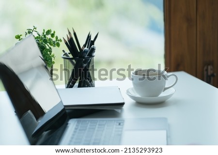 Close-up image of an office desk at morning with a cup of tea and financial documents.