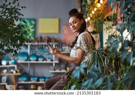 Serene floriculturist with a smartphone looking ahead Royalty-Free Stock Photo #2135301183
