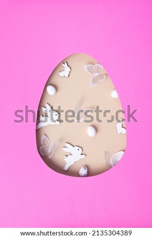 Easter egg cut out of paper and eggs, bunnies and butterflies. Creative Easter holiday concept, greeting card.