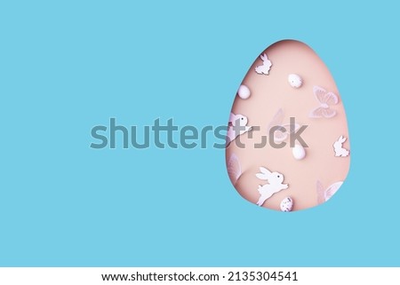 Easter egg cut out of paper and eggs, bunny and butterflies. Creative Easter holiday concept with copy space.