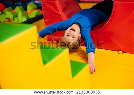 Active children's games in play center, playroom, playground. Little boy is playing among soft blocks. Royalty-Free Stock Photo #2135308955