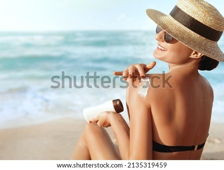 Woman apply sun cream protection  on her tanned Shoulder. Skin and Body Care.Portrait Of Female Holding Moisturizing Sunblock. Royalty-Free Stock Photo #2135319459