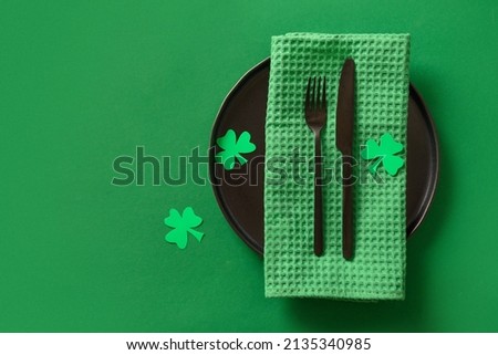 Table setting with tradition St Patrick's Day green decoration on green background. View from above. Space for text.