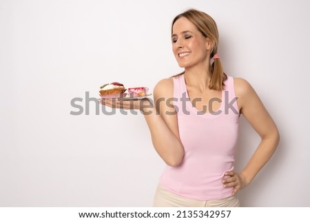 Image of happy woman in casual clothes holding piece of birthday cake isolated over white background. Celebration concept.