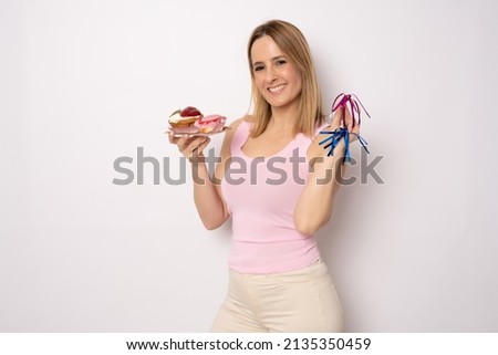 Image of happy woman in casual clothes holding piece of birthday cake with candle isolated over white background. Celebration concept.