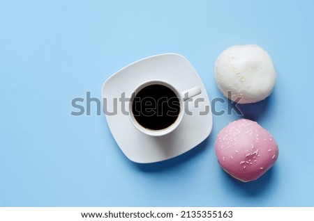 Morning with cup of hot coffee and sweet donuts on blue background. Top view, copy space, mockup. Flat lay. Food and drinks. Spring holidays. 