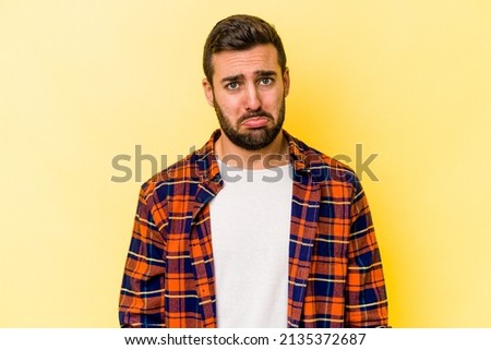 Young caucasian man isolated on yellow background sad, serious face, feeling miserable and displeased. Royalty-Free Stock Photo #2135372687