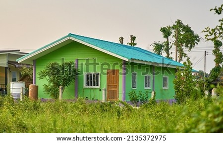 A small simple house in a grass background.        Royalty-Free Stock Photo #2135372975