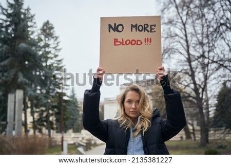 Young caucasian woman standing with manifest banner on cardboard