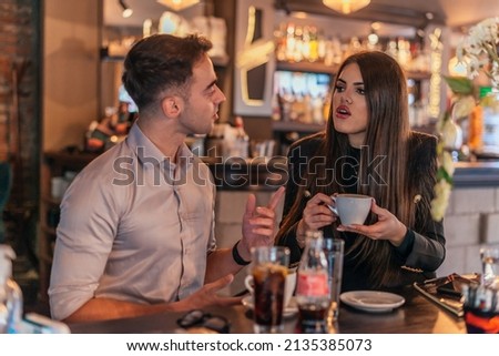Close up picture of two business colleagues talking in a bar and drinking coffee