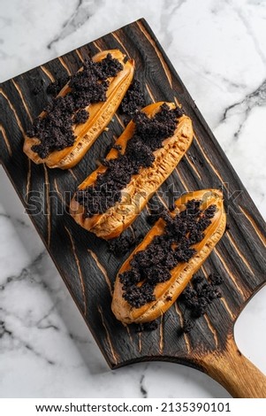 Eclairs with poppy seeds and cream. Top view. Free space for text.