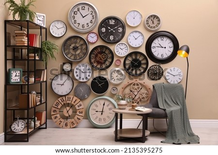 Stylish room interior with collection of wall clocks