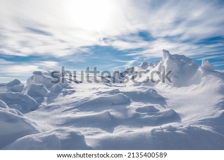 A large pile of snow after a blizzard and snowfall looks like mountain peaks. Royalty-Free Stock Photo #2135400589