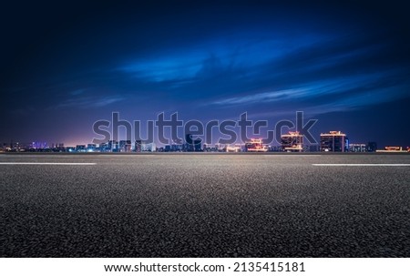 The night view of the city in front of the asphalt road Royalty-Free Stock Photo #2135415181
