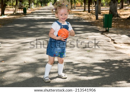 Little girl with ball in park on nature at summer. Use it for baby and sport  concept