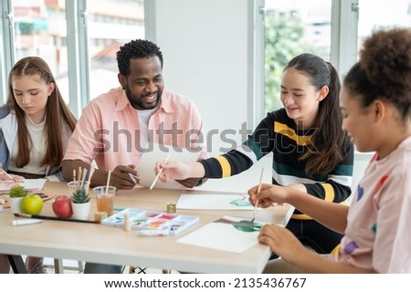 Part-time art teacher with children drawing, practicing drawing and painting. Special classroom. Concept Home school, teaching modifications for children.