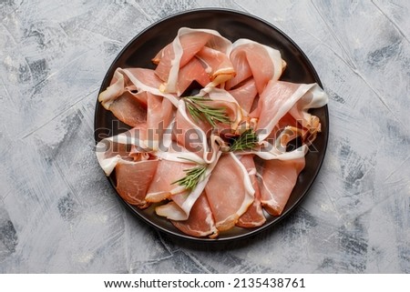 Prosciutto crudo, Italian salami, parma ham. Antipasto plate. Gray background, top view. Copy space Royalty-Free Stock Photo #2135438761
