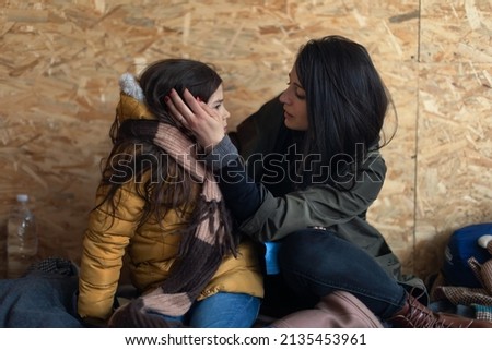 Ukrainian war refugees in temporary shelter and help center, little girl with her mother. Royalty-Free Stock Photo #2135453961