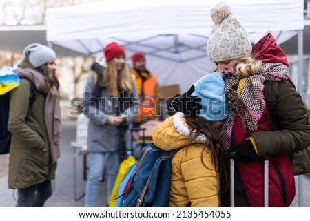 Ukrainian refugee mother with child crossing border. Royalty-Free Stock Photo #2135454055