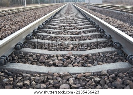 Railway lines with track ballast. Train tracks underlay, rails and crushed stones. Industrial landscape. Railway junction. Heavy industry. Railway track.                       Royalty-Free Stock Photo #2135456423