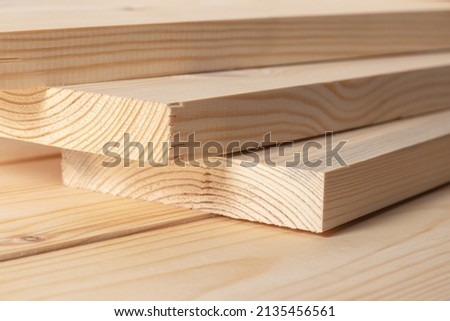 Stacks of pine wood planks. Natural rough wooden boards boards, lumber, industrial wood, timber. Royalty-Free Stock Photo #2135456561