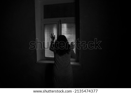 Horror silhouette inside abandoned creepy room with window at night. Horror scene. Halloween concept.