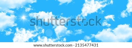 horizontal blue sky background image. panoramic sky view. sun rays among the clouds.