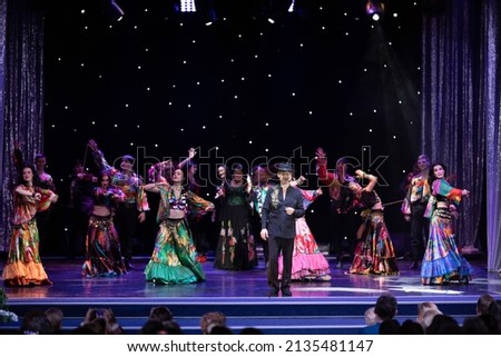 A collective of musicians, singers and dancers in gypsy costumes perform on stage. Royalty-Free Stock Photo #2135481147