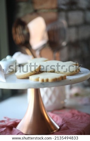 Sugar cookies not decorated on copper cake stand with rustic background Royalty-Free Stock Photo #2135494833