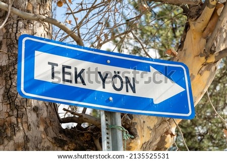 Turkish "One Way" traffic sign. Information sign showing that the street has only one entrance. Blue metal sign and white arrow.